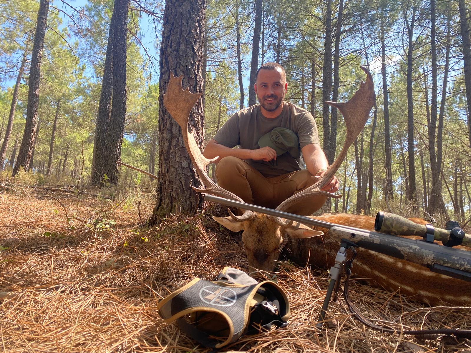 Julián Domínguez junto a un gamo en un pinar